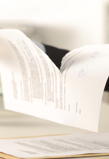 Person tearing up a document with information